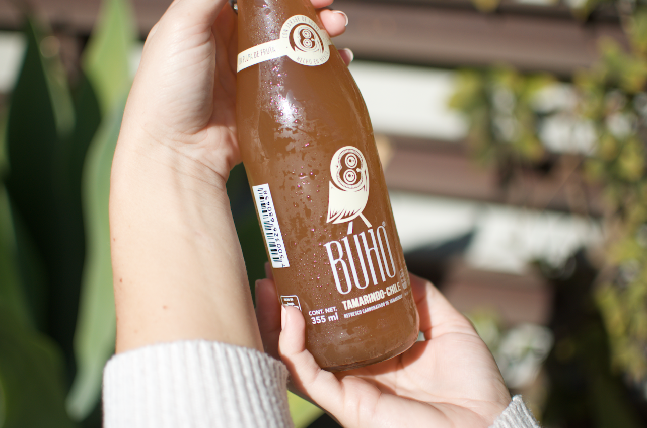 Woman Holding a Refreshing Bottle of Buho Soda with two hands
