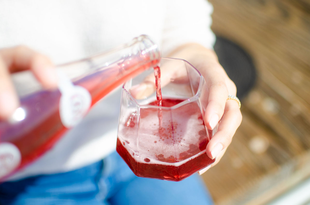 A Woman pouring a delicious Buho Soda into a glass