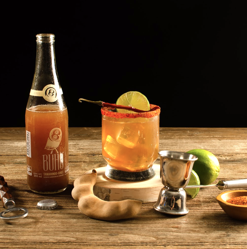 A beautiful bottle of Buho Soda in a cup with ice with drink mixing materials